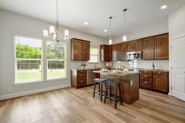 2109 Meadow View Dr, San Marcos, TX 78666 - kitchen featuring stainless steel appliances, a center island, tasteful backsplash, light wood-style floors, and recessed lighting
