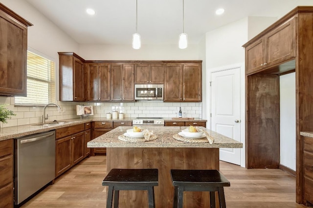 2109 Meadow View Dr, San Marcos, TX 78666 - kitchen featuring stainless steel appliances, light wood finished floors, a center island, tasteful backsplash, and pendant lighting