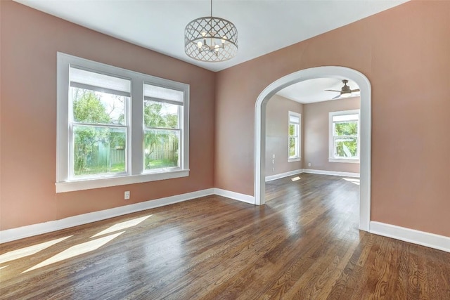 4412 Red River St, Austin, TX 78751 - empty room featuring arched walkways, dark wood-style floors, and a chandelier