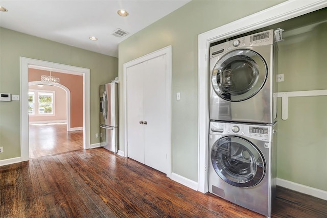 4412 Red River St, Austin, TX 78751 - laundry room featuring stacked washer and clothes dryer, dark wood-style floors, recessed lighting, arched walkways, and a chandelier