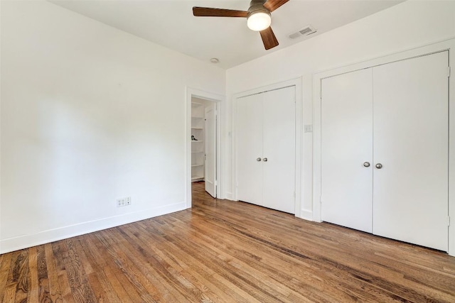 4412 Red River St, Austin, TX 78751 - unfurnished bedroom featuring two closets, wood finished floors, and a ceiling fan