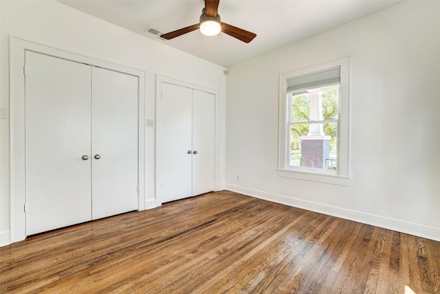 4412 Red River St, Austin, TX 78751 - unfurnished bedroom with two closets, wood finished floors, and ceiling fan
