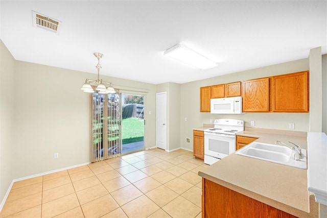 311 Carol Ave, Leander, TX 78641 - kitchen with white appliances, a chandelier, light countertops, light tile patterned floors, and hanging light fixtures