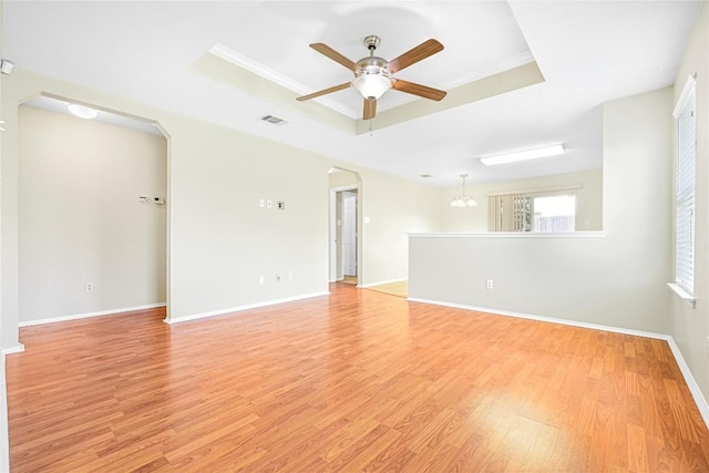 311 Carol Ave, Leander, TX 78641 - spare room with a tray ceiling, ceiling fan, arched walkways, light wood-style floors, and crown molding