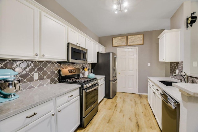1141 Stone Forest Trl, Round Rock, TX 78681 - kitchen featuring stainless steel appliances, white cabinetry, tasteful backsplash, light wood-style flooring, and light stone counters