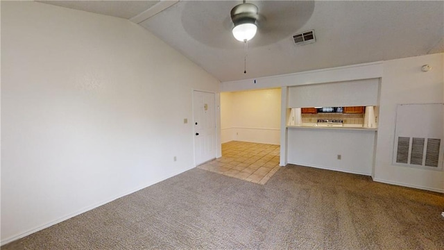 unfurnished living room featuring ceiling fan, vaulted ceiling, and carpet