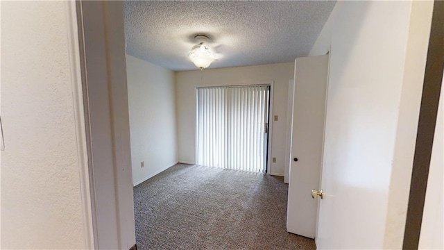 unfurnished room featuring carpet flooring and a textured ceiling