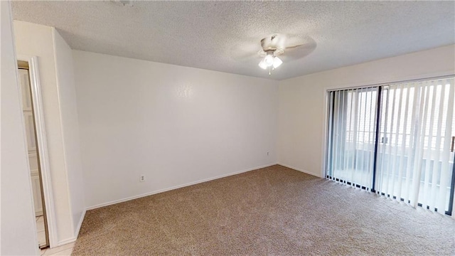unfurnished room featuring light colored carpet, a ceiling fan, and a textured ceiling