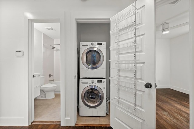 4706 Louis Ave, Austin, TX 78721 - laundry room featuring estacked washer and dryer and dark wood-type flooring