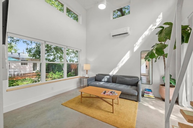 4706 Louis Ave, Austin, TX 78721 - living area featuring a wall mounted AC, plenty of natural light, concrete flooring, and a towering ceiling