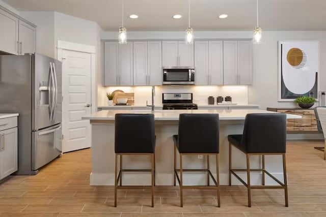 621 Runnel Dr, Leander, TX 78641 - kitchen featuring stainless steel appliances, light wood-style flooring, light countertops, gray cabinets, and recessed lighting