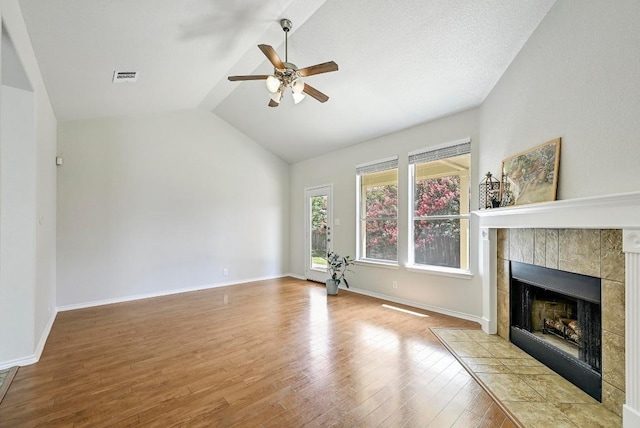 1921 Sand Creek Rd, Cedar Park, TX 78613 - unfurnished living room with ceiling fan, wood finished floors, lofted ceiling, and a tile fireplace