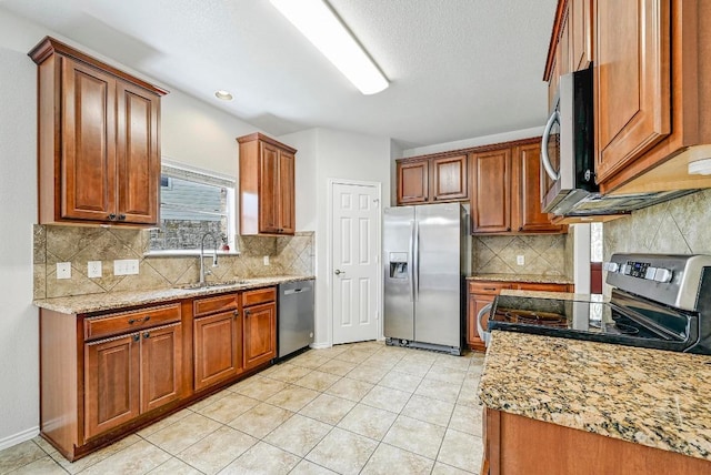 1921 Sand Creek Rd, Cedar Park, TX 78613 - kitchen with appliances with stainless steel finishes, backsplash, brown cabinets, and light tile patterned floors