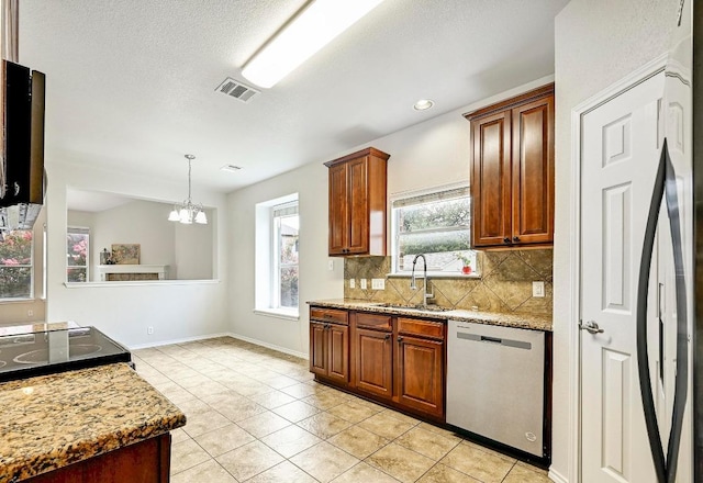 1921 Sand Creek Rd, Cedar Park, TX 78613 - kitchen with stainless steel dishwasher, decorative backsplash, light tile patterned floors, a chandelier, and hanging light fixtures