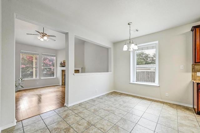 1921 Sand Creek Rd, Cedar Park, TX 78613 - unfurnished dining area featuring light tile patterned flooring, a chandelier, and a ceiling fan