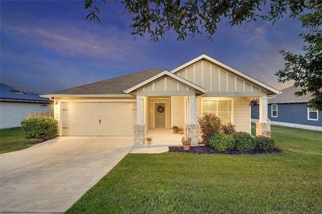 605 Liard River Rd, Hutto, TX 78634 - view of front facade featuring board and batten siding, a garage, driveway, a front yard, and stone siding