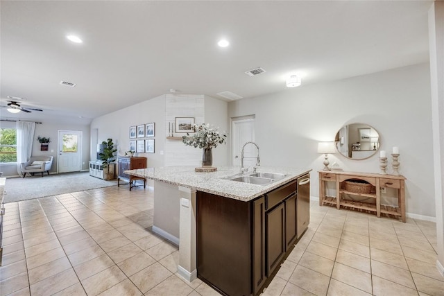 605 Liard River Rd, Hutto, TX 78634 - kitchen with light tile patterned flooring, an island with sink, dark brown cabinetry, open floor plan, and recessed lighting
