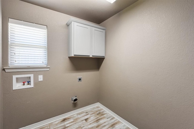 8305 Split Trail Cv, Temple, TX 76502 - laundry area with electric dryer hookup, hookup for a washing machine, cabinet space, and light wood-style floors