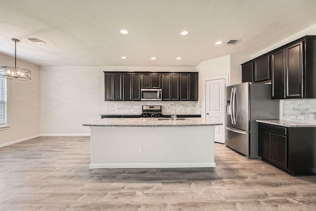 16912 Alturas Ave, Pflugerville, TX 78660 - kitchen with stainless steel appliances, decorative backsplash, light stone countertops, light wood-style flooring, and recessed lighting