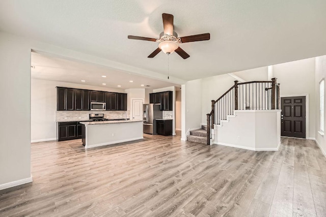 16912 Alturas Ave, Pflugerville, TX 78660 - unfurnished living room with ceiling fan, light wood-style floors, stairs, and recessed lighting