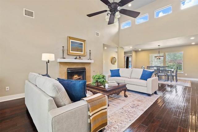 4104 Honeycomb Rock Cir, Austin, TX 78731 - living area featuring ceiling fan, a lit fireplace, dark wood-style floors, a high ceiling, and a chandelier