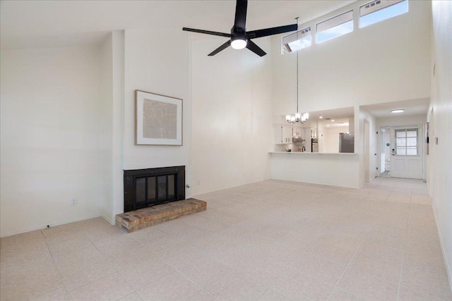 8432 Antero Dr, Austin, TX 78759 - unfurnished living room featuring a chandelier, a brick fireplace, a towering ceiling, and ceiling fan
