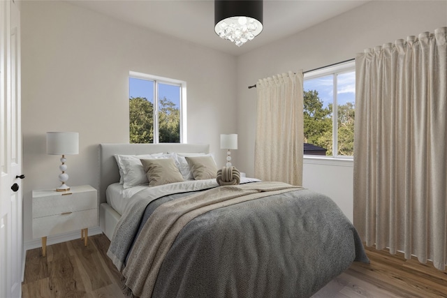 790 Enchanted Oaks Dr, Driftwood, TX 78619 - bedroom with wood finished floors and a chandelier