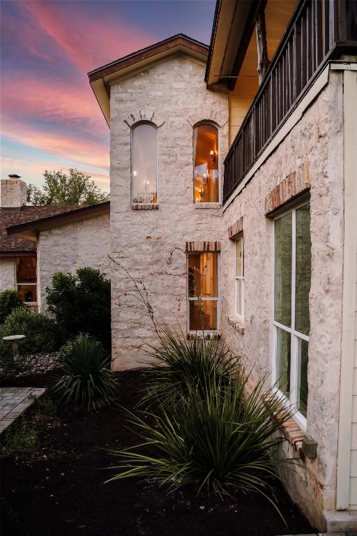 790 Enchanted Oaks Dr, Driftwood, TX 78619 - property exterior at dusk with a balcony