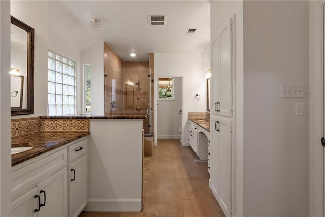 790 Enchanted Oaks Dr, Driftwood, TX 78619 - full bathroom with two vanities, a stall shower, tile patterned flooring, and tasteful backsplash