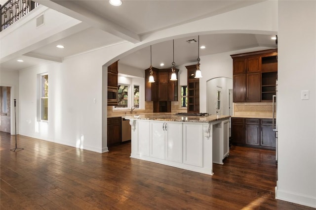 790 Enchanted Oaks Dr, Driftwood, TX 78619 - kitchen featuring tasteful backsplash, dark wood-style flooring, a center island, arched walkways, and appliances with stainless steel finishes