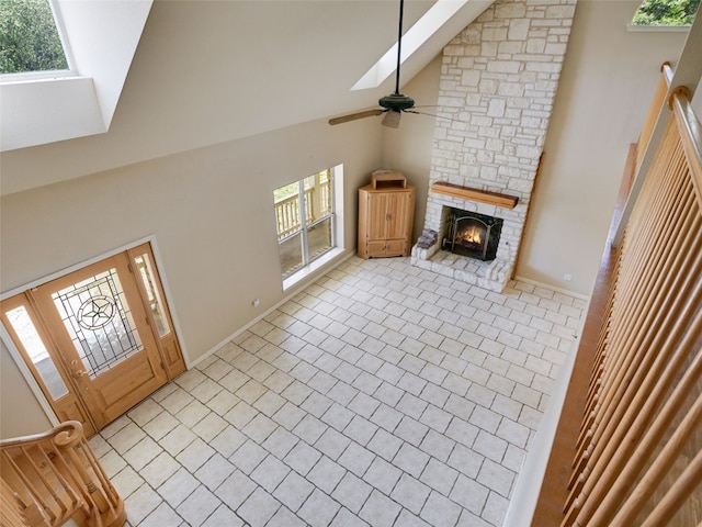 900 Crk 282, Liberty Hill, TX 78642 - unfurnished living room featuring high vaulted ceiling, a skylight, ceiling fan, and a fireplace
