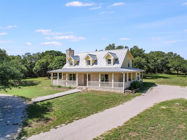 900 Crk 282, Liberty Hill, TX 78642 - country-style home featuring a standing seam roof, covered porch, a chimney, dirt driveway, and a front lawn