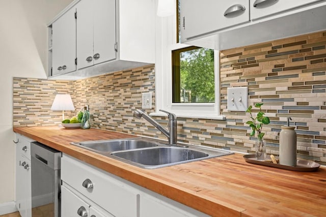 1209 Payne Ave, Austin, TX 78757 - kitchen featuring stainless steel dishwasher, wooden counters, backsplash, and white cabinets