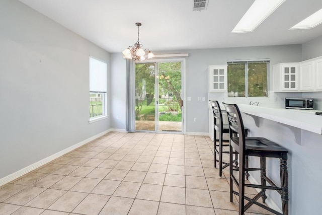 113 Stetson Trl, Georgetown, TX 78633 - kitchen featuring stainless steel microwave, a chandelier, light countertops, white cabinets, and a kitchen bar