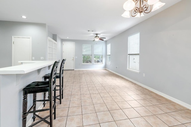 113 Stetson Trl, Georgetown, TX 78633 - kitchen with light tile patterned floors, recessed lighting, a kitchen bar, a chandelier, and light countertops
