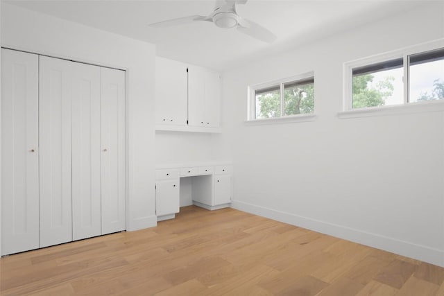 11707 Barrington Way, Austin, TX 78759 - unfurnished bedroom featuring built in study area, light wood-style flooring, a closet, and a ceiling fan