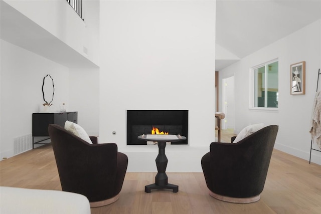 11707 Barrington Way, Austin, TX 78759 - living area featuring wood finished floors, a lit fireplace, and a high ceiling