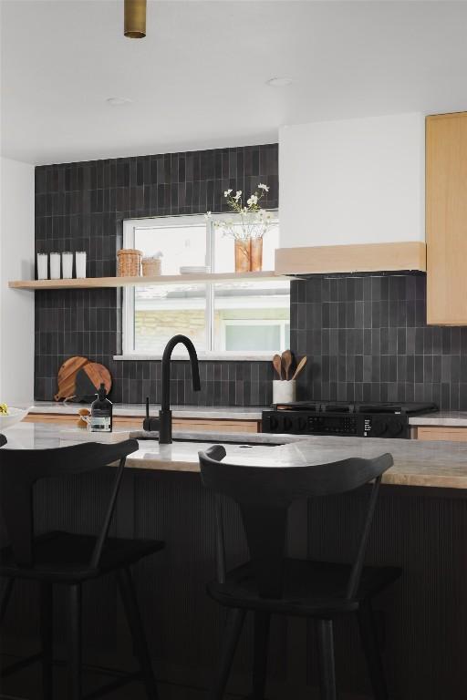11707 Barrington Way, Austin, TX 78759 - kitchen featuring decorative backsplash, light countertops, and a kitchen breakfast bar