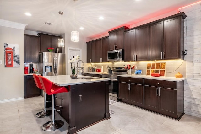 540 Appalachian Trl, Leander, TX 78641 - kitchen with appliances with stainless steel finishes, light countertops, decorative backsplash, a breakfast bar area, and a center island with sink