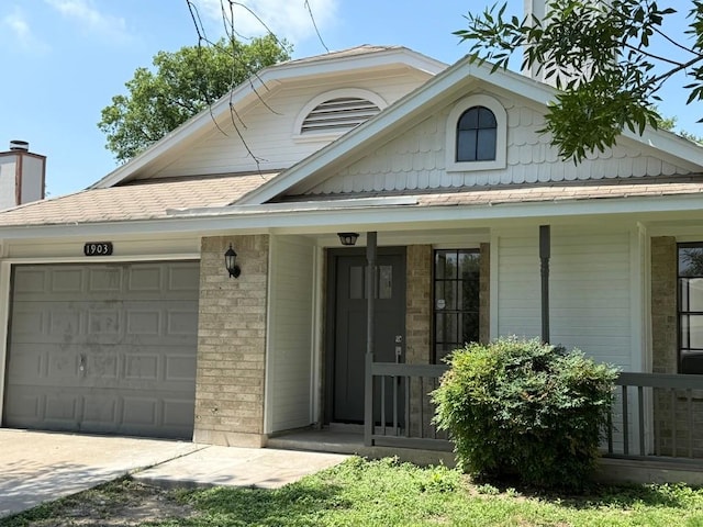 1903 Golden Pheasant Dr, Austin, TX 78758 - view of front facade featuring an attached garage, covered porch, brick siding, and concrete driveway