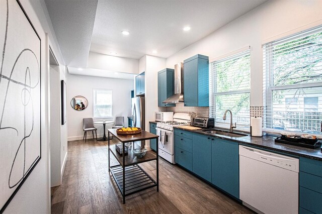 3405 Cedar St, Austin, TX 78705 - kitchen with white appliances, blue cabinetry, wall chimney exhaust hood, dark wood-style floors, and backsplash