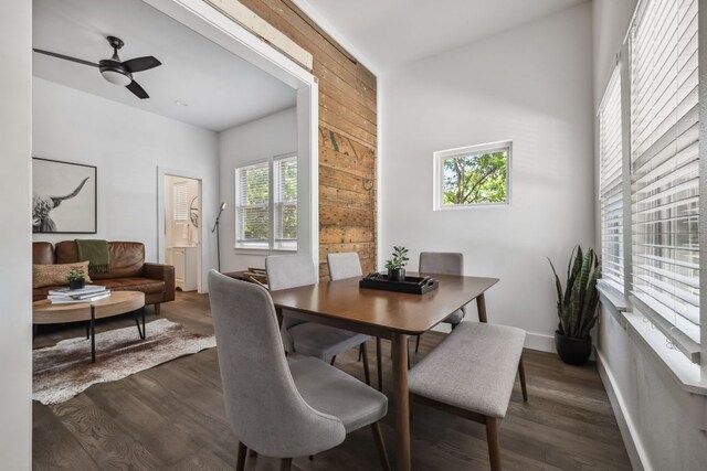 3405 Cedar St, Austin, TX 78705 - dining area with a ceiling fan, wood walls, and dark wood-style flooring