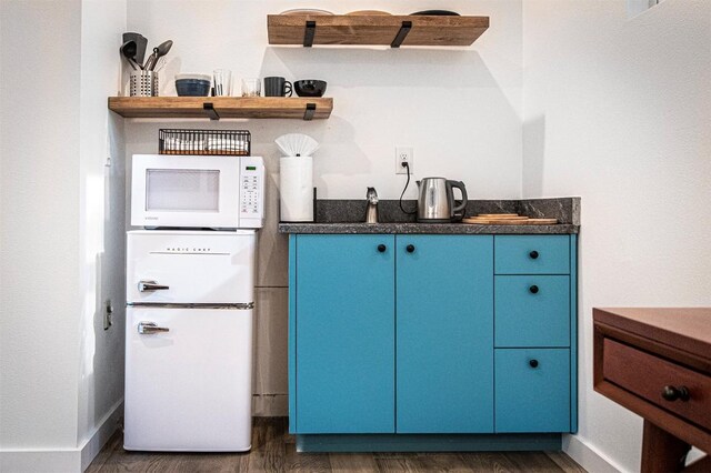 3405 Cedar St, Austin, TX 78705 - kitchen with white microwave, fridge, wood finished floors, open shelves, and blue cabinets