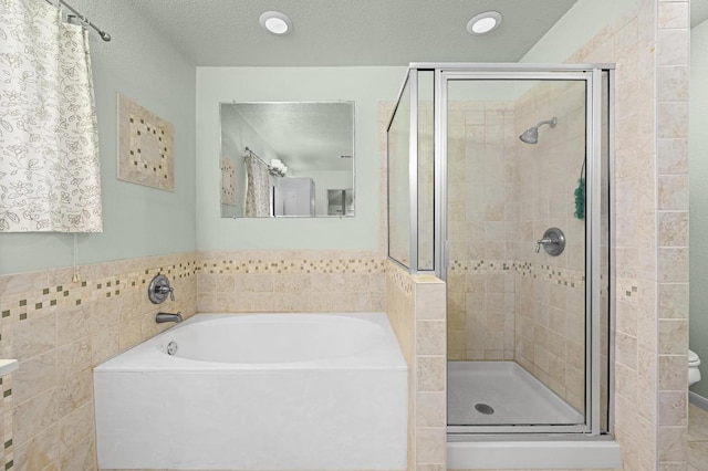 1831 Greening Way, Leander, TX 78641 - full bath featuring a shower stall, a garden tub, a textured ceiling, and tile walls
