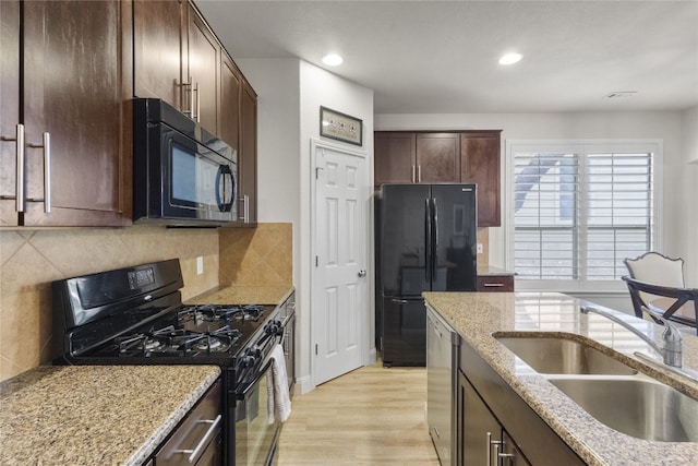 11400 W Parmer Ln Unit 4, Cedar Park, TX 78613 - kitchen with black appliances, light wood-type flooring, recessed lighting, light stone counters, and dark brown cabinetry
