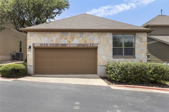 11400 W Parmer Ln Unit 4, Cedar Park, TX 78613 - view of side of home featuring stone siding, an attached garage, a shingled roof, and driveway