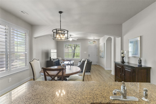 11400 W Parmer Ln Unit 4, Cedar Park, TX 78613 - dining room with arched walkways, a chandelier, light wood-type flooring, and ceiling fan
