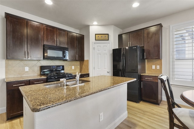 11400 W Parmer Ln Unit 4, Cedar Park, TX 78613 - kitchen with black appliances, stone countertops, light wood-style flooring, recessed lighting, and dark brown cabinets