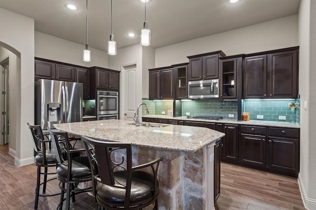 413 Fair Oaks Dr, Georgetown, TX 78628 - kitchen with stainless steel appliances, a kitchen breakfast bar, dark brown cabinets, pendant lighting, and recessed lighting