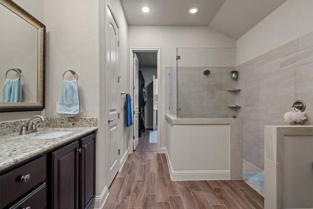 413 Fair Oaks Dr, Georgetown, TX 78628 - full bathroom with walk in shower, vanity, wood finished floors, vaulted ceiling, and recessed lighting